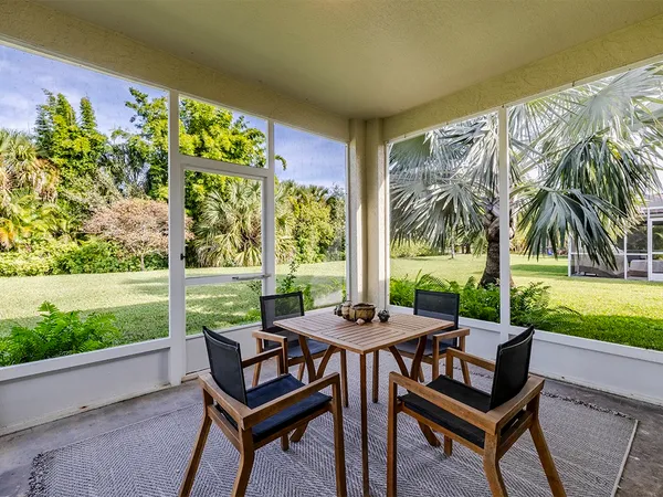 a view of a patio with a table chairs and a yard