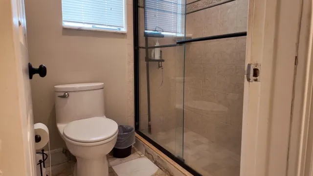 a bathroom with a toilet and a shower