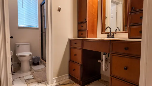 a bathroom with a toilet a sink and mirror