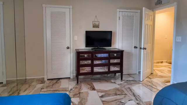 a bedroom with a bed and a flat screen tv