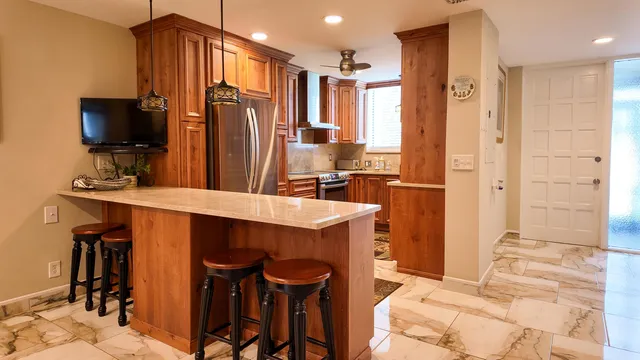 a kitchen with stainless steel appliances kitchen island granite countertop a refrigerator and a stove top oven