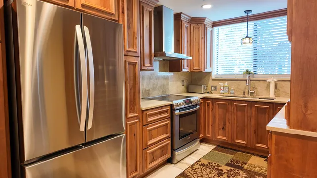 a kitchen with stainless steel appliances granite countertop a refrigerator and a sink