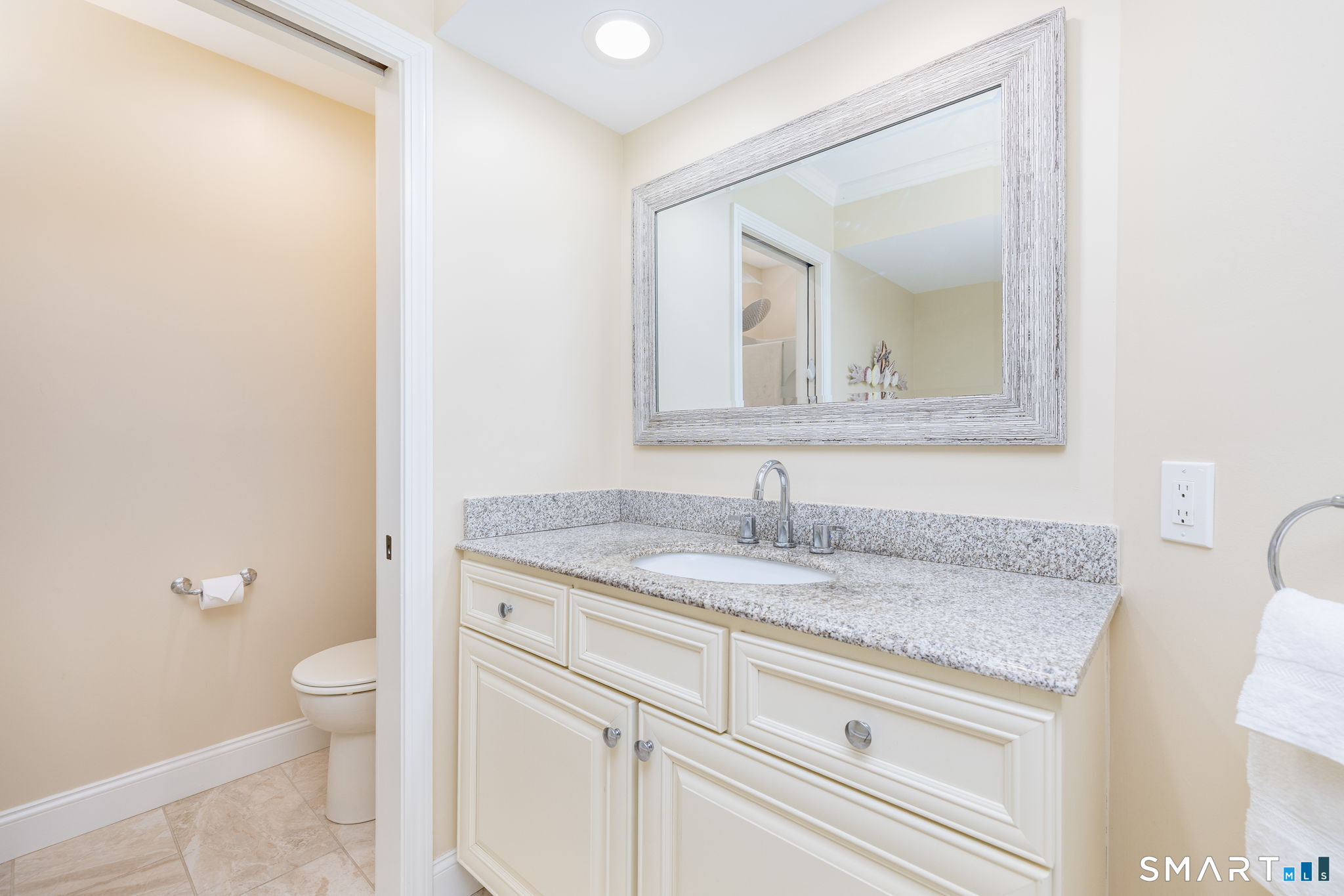 85 Gate Ridge Road, Unit 85 Fairfield, CT 06825 - Photo 17 of 38 a bathroom with a granite countertop sink a toilet and a mirror