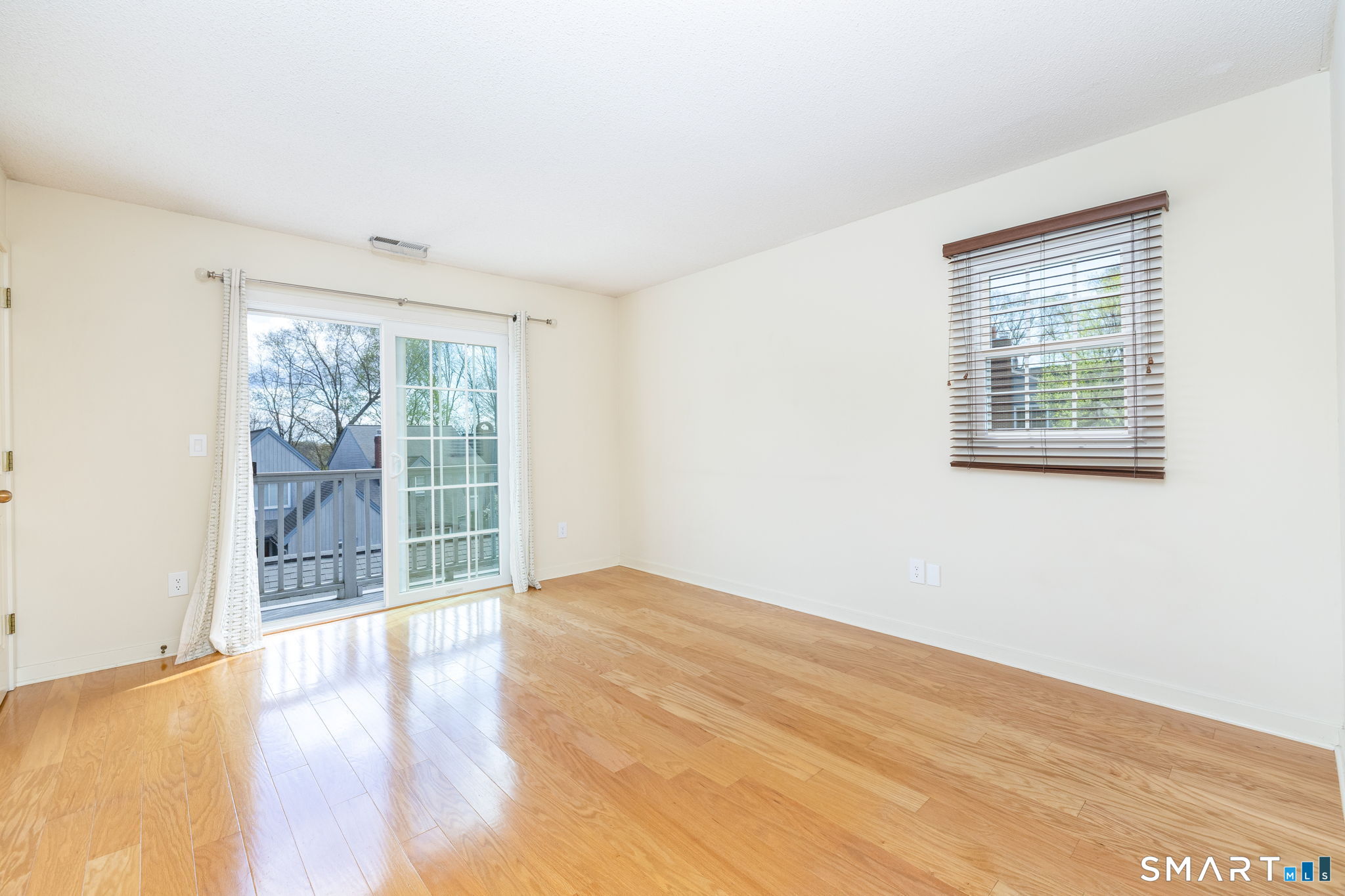 85 Gate Ridge Road, Unit 85 Fairfield, CT 06825 - Photo 20 of 38 a view of an empty room with wooden floor and a window