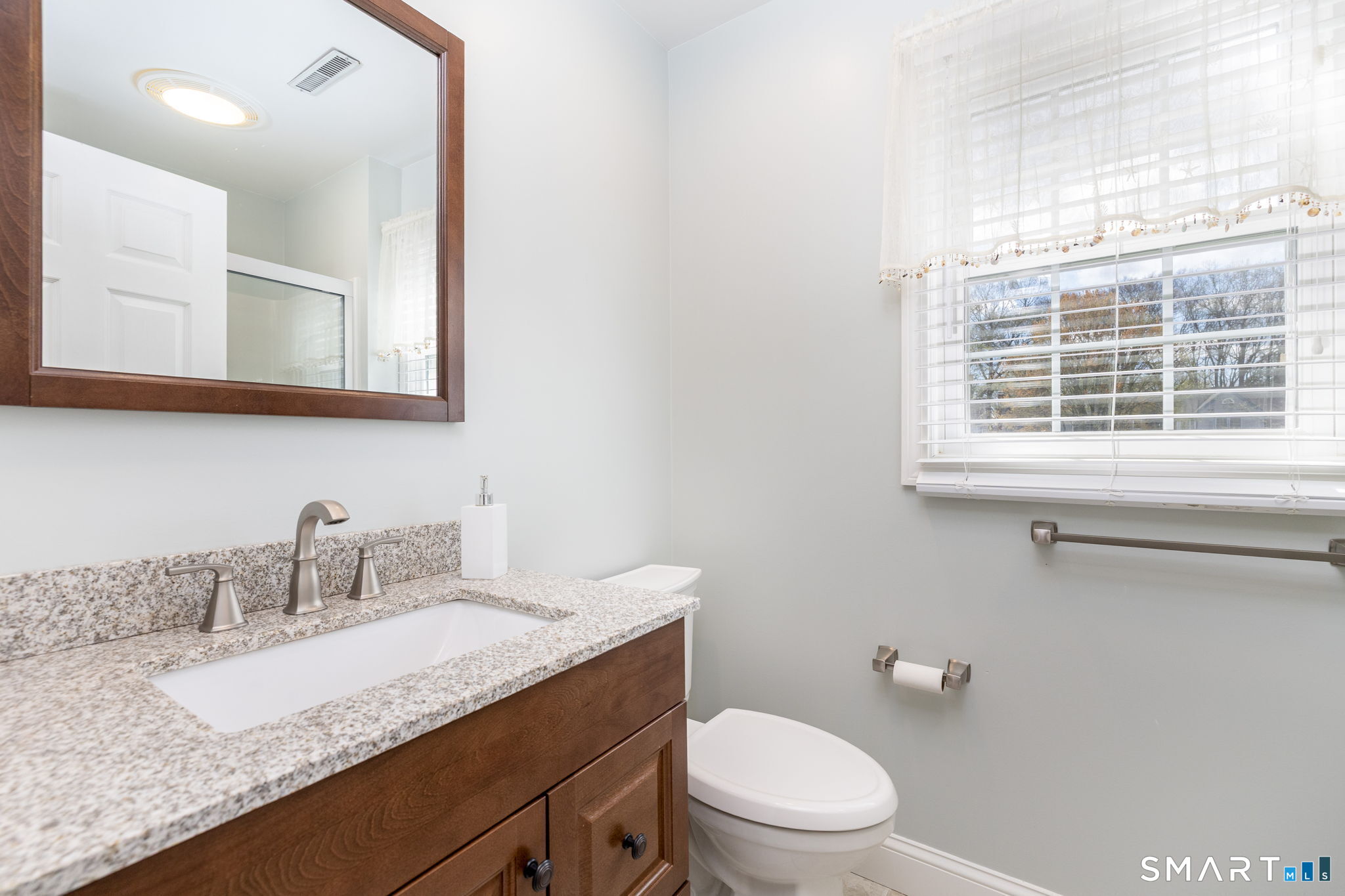 85 Gate Ridge Road, Unit 85 Fairfield, CT 06825 - Photo 24 of 38 a bathroom with a granite countertop sink a large mirror and a toilet
