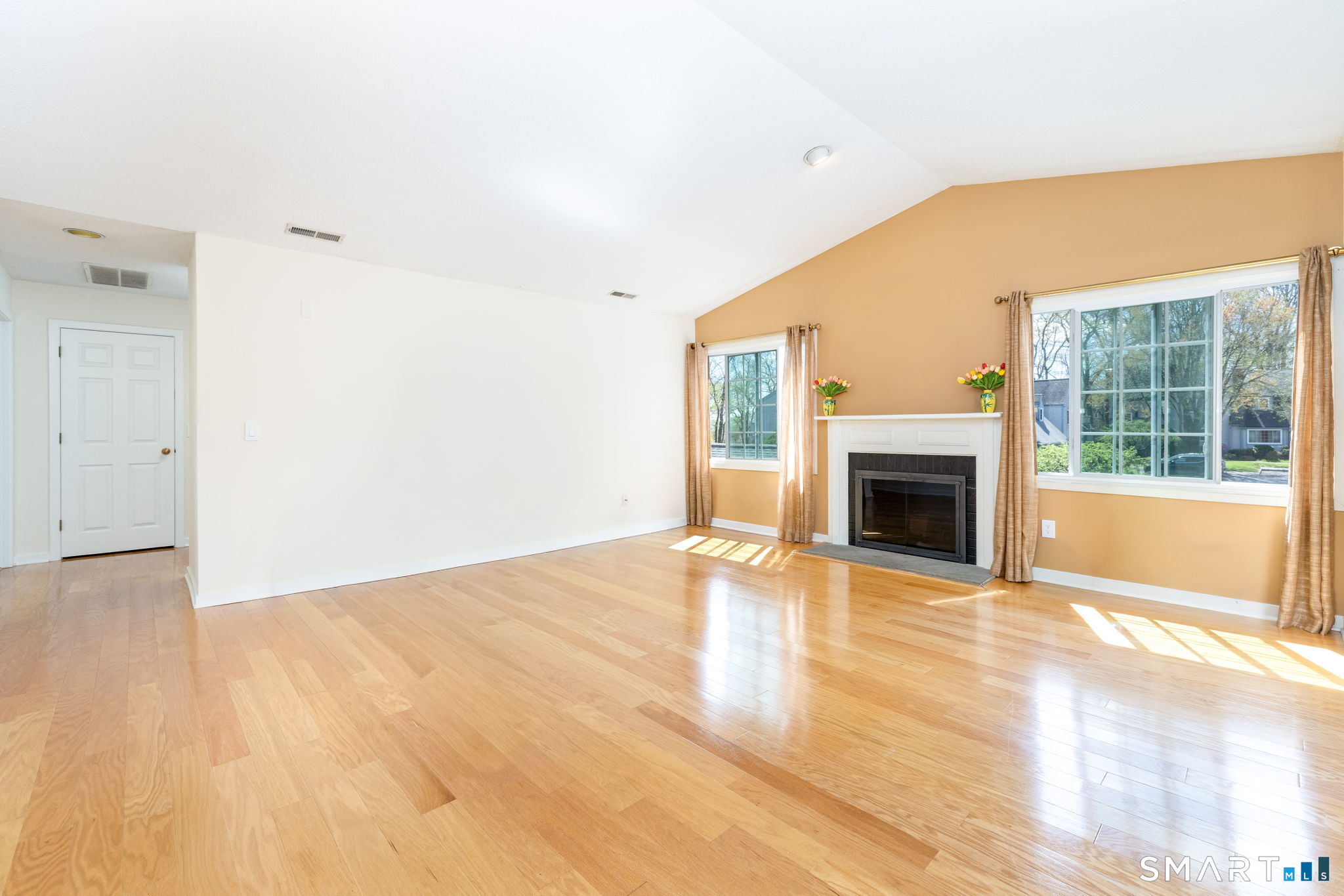 85 Gate Ridge Road, Unit 85 Fairfield, CT 06825 - Photo 3 of 38 a view of empty room with wooden floor and fireplace