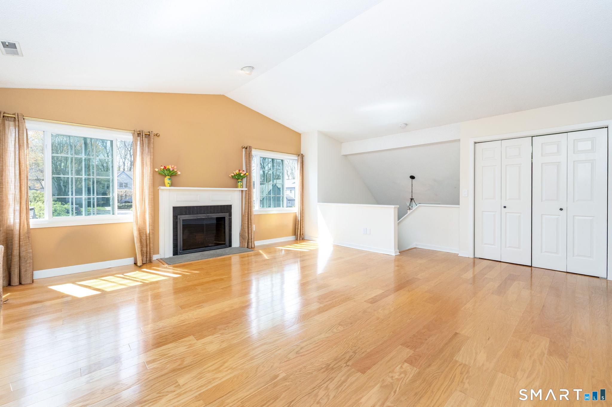 85 Gate Ridge Road, Unit 85 Fairfield, CT 06825 - Photo 5 of 38 a view of empty room with wooden floor and fireplace