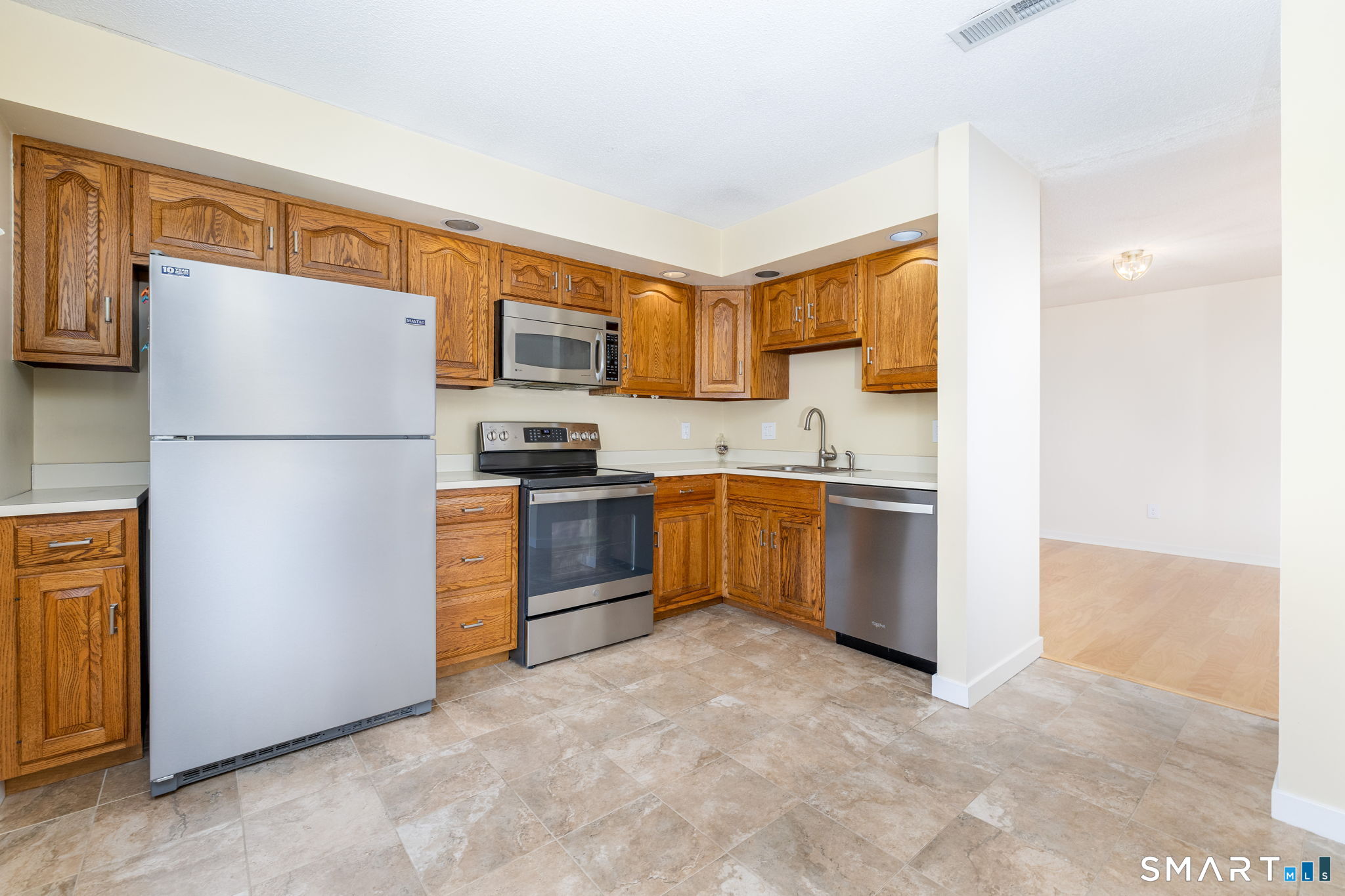 85 Gate Ridge Road, Unit 85 Fairfield, CT 06825 - Photo 6 of 38 a kitchen with stainless steel appliances granite countertop a refrigerator a stove and a sink
