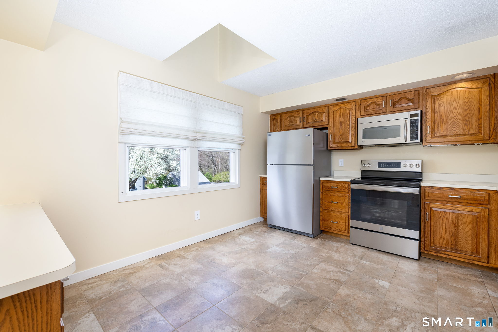 85 Gate Ridge Road, Unit 85 Fairfield, CT 06825 - Photo 7 of 38 a kitchen with stainless steel appliances a refrigerator and a stove top oven