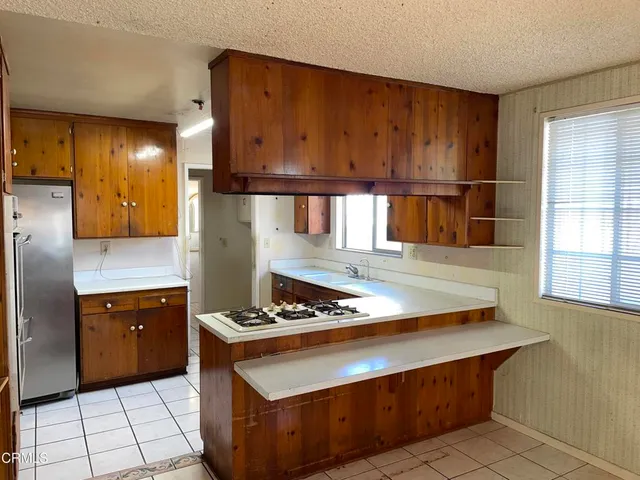 a kitchen with stainless steel appliances granite countertop a refrigerator and a stove