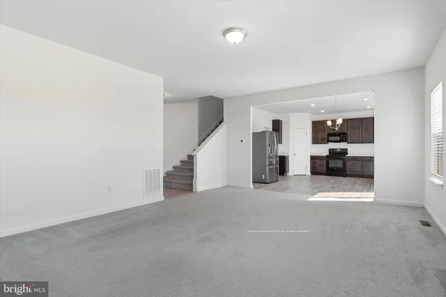 a kitchen with stainless steel appliances granite countertop a refrigerator a sink dishwasher a stove and a refrigerator