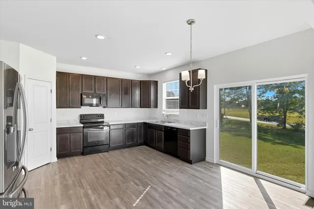 a kitchen with stainless steel appliances granite countertop a refrigerator a stove a sink and dishwasher