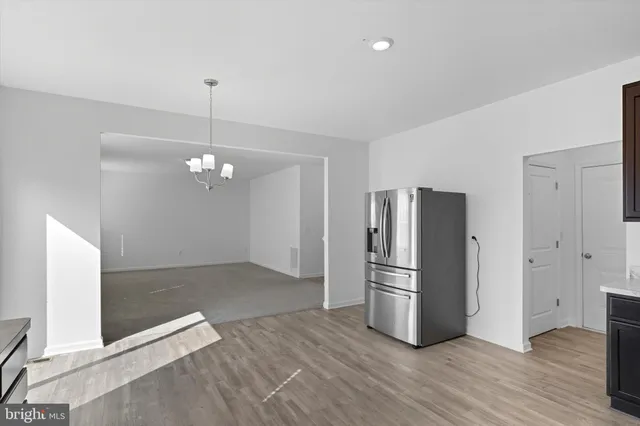 a large kitchen with stainless steel appliances granite countertop a sink and wooden cabinets