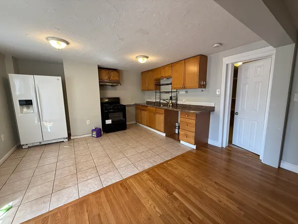 a large kitchen with cabinets and wooden floor