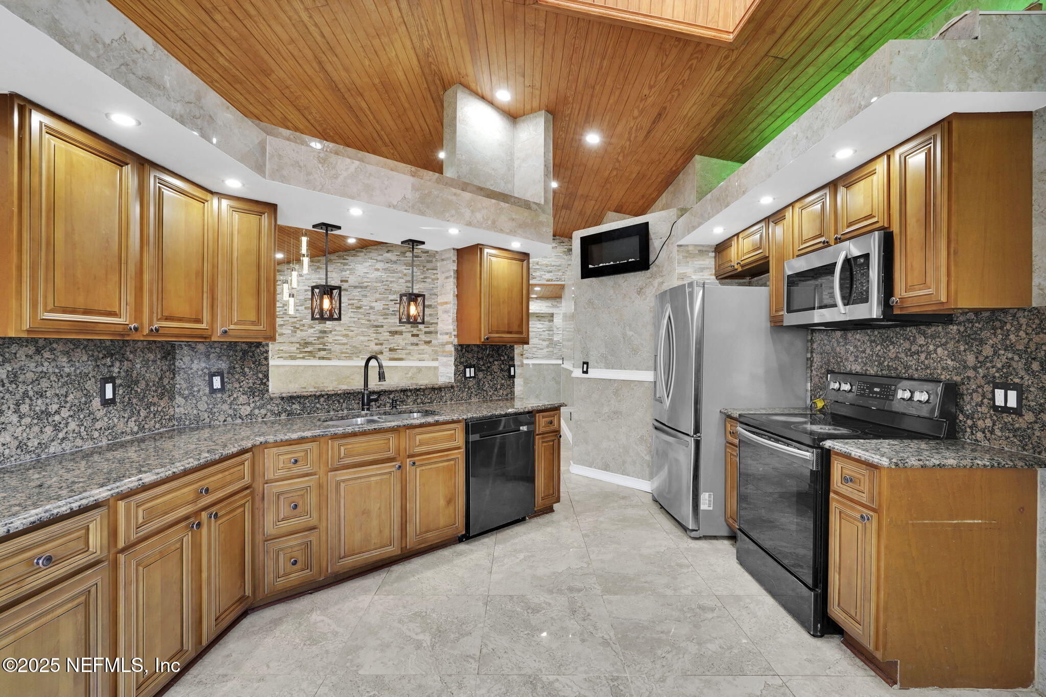 8786 Spring Harvest Lane East Jacksonville, FL 32244 - Photo 15 of 39 a kitchen with stainless steel appliances granite countertop a sink a stove a refrigerator cabinets and a microwave