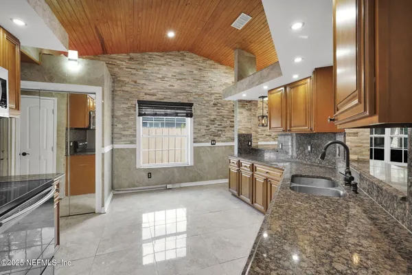 a kitchen with stainless steel appliances granite countertop a sink and cabinets