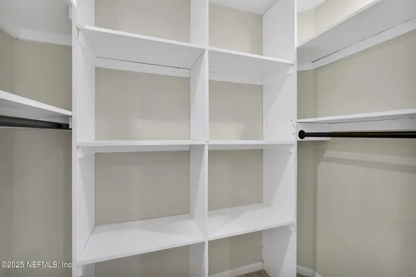 a view of walk in closet with empty racks