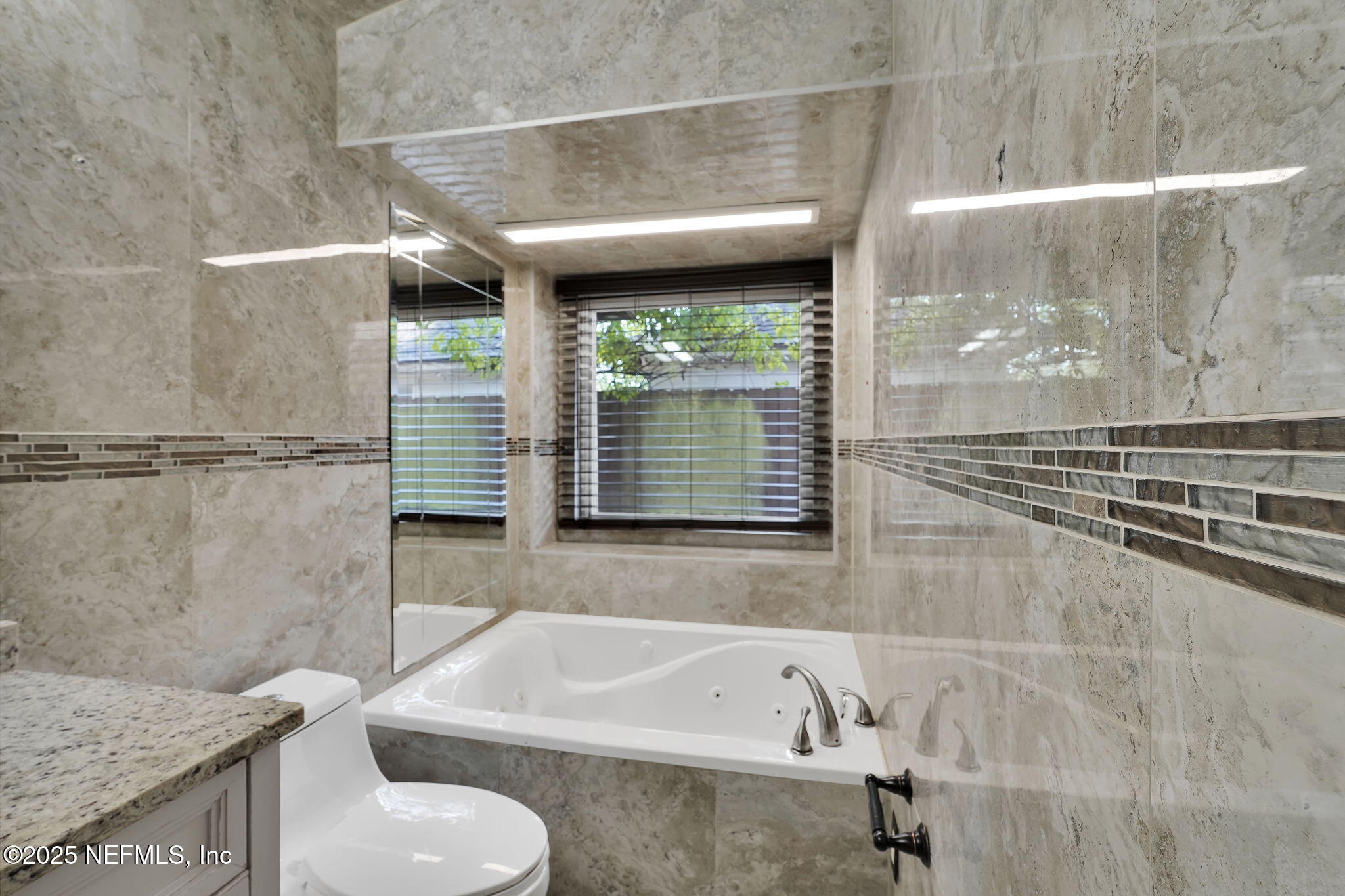 8786 Spring Harvest Lane East Jacksonville, FL 32244 - Photo 26 of 39 a bathroom with a tub a sink and a window