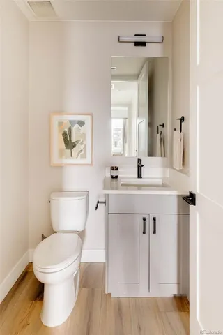 a bathroom with a toilet a sink and mirror
