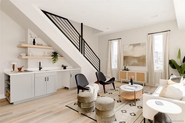 a living room with furniture a rug and white walls