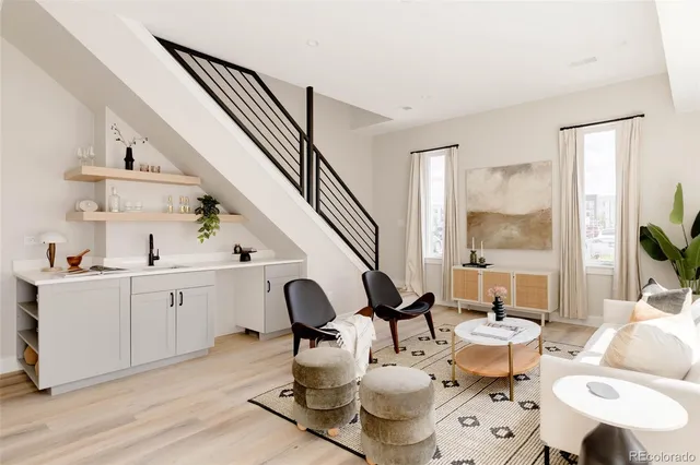 a living room with furniture a rug and white walls
