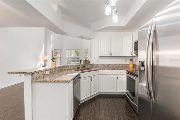 a kitchen with stainless steel appliances granite countertop a sink stove and refrigerator