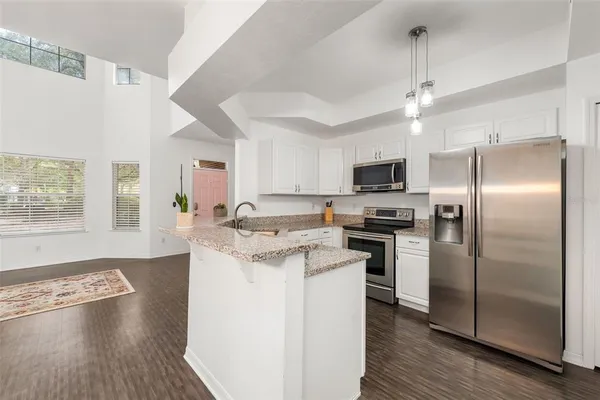 a kitchen with stainless steel appliances granite countertop a refrigerator a stove a sink and a microwave