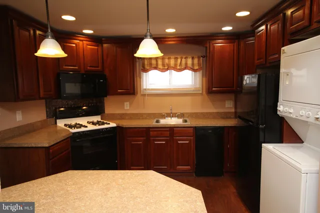 a kitchen with stainless steel appliances granite countertop a sink a stove and a refrigerator