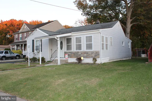 a front view of a house with a garden and trees