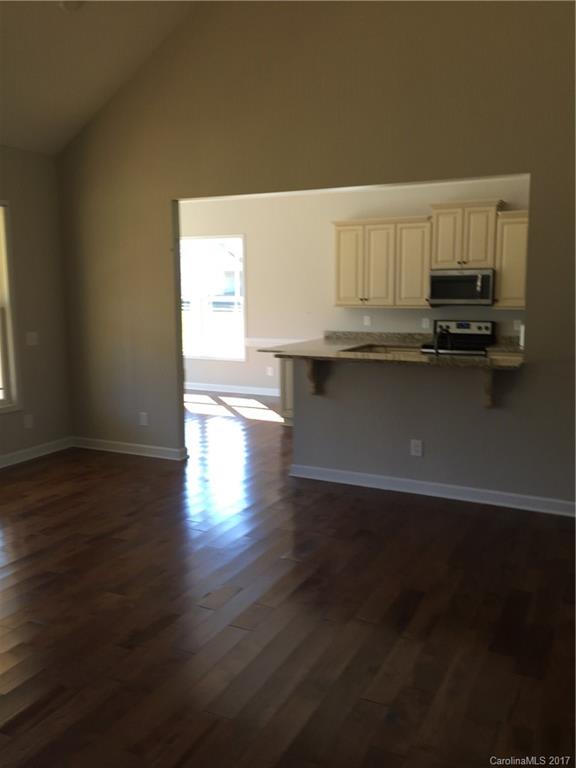 1854 State Rd S-46-168, Unit 4 York, SC 29745 - Photo 11 of 20 a kitchen with granite countertop a stove and a wooden floor