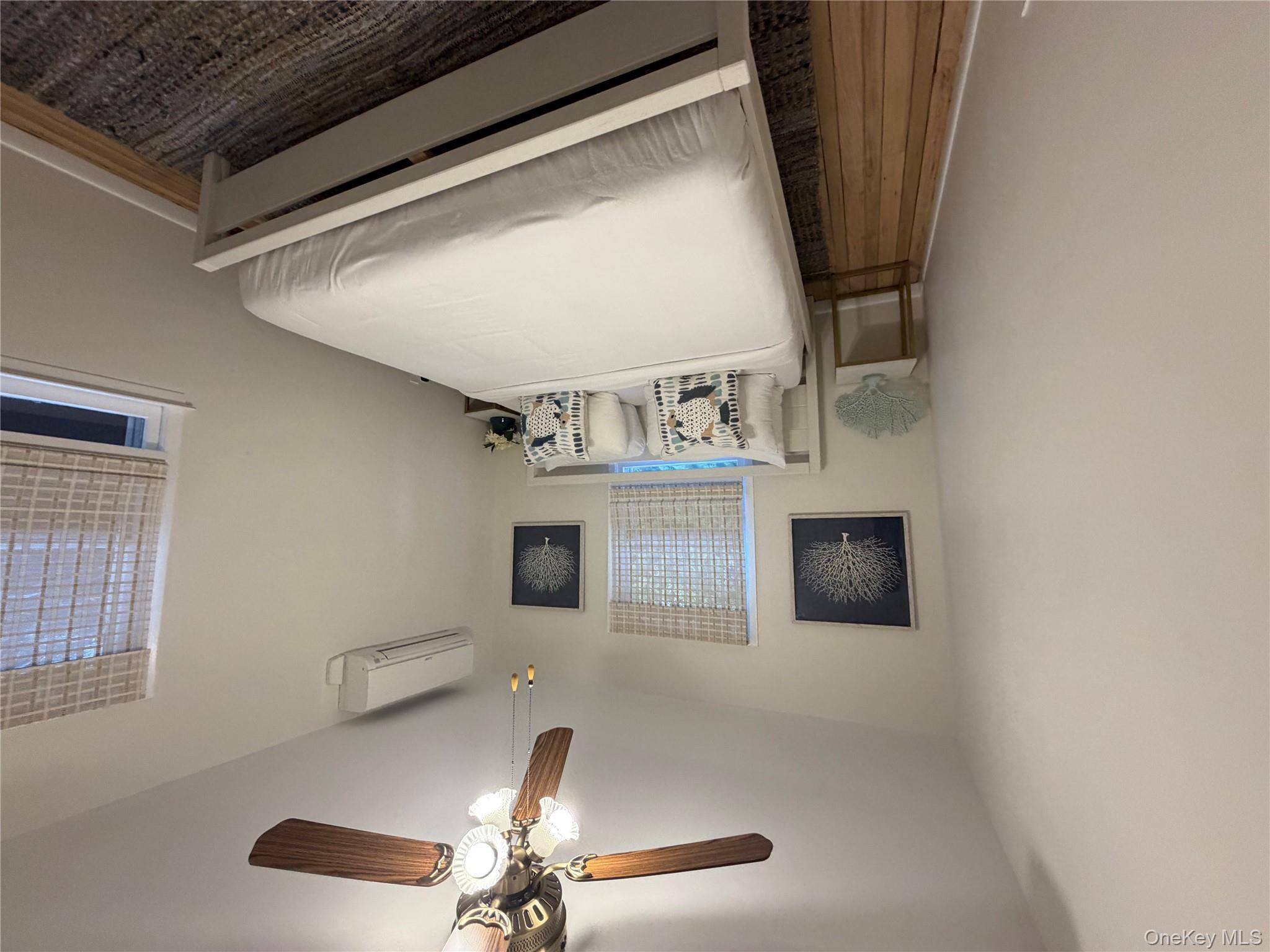 380 Eds Road Southold, NY 11971 - Photo 10 of 19 Bedroom with a ceiling fan, wood finished floors, and an AC wall unit