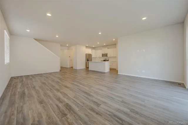 a view of empty room with wooden floor