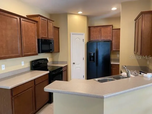a kitchen with stainless steel appliances a refrigerator sink and microwave