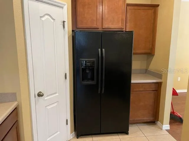 an empty room with wooden floor chandelier fan and windows
