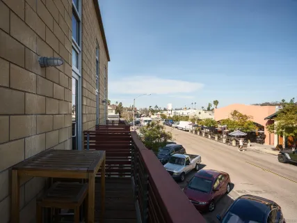 a city street lined with parked cars front of buildings