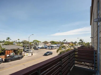a front view of a building with lot of cars parked on road