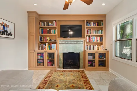 a living room with bookshelf and a fireplace