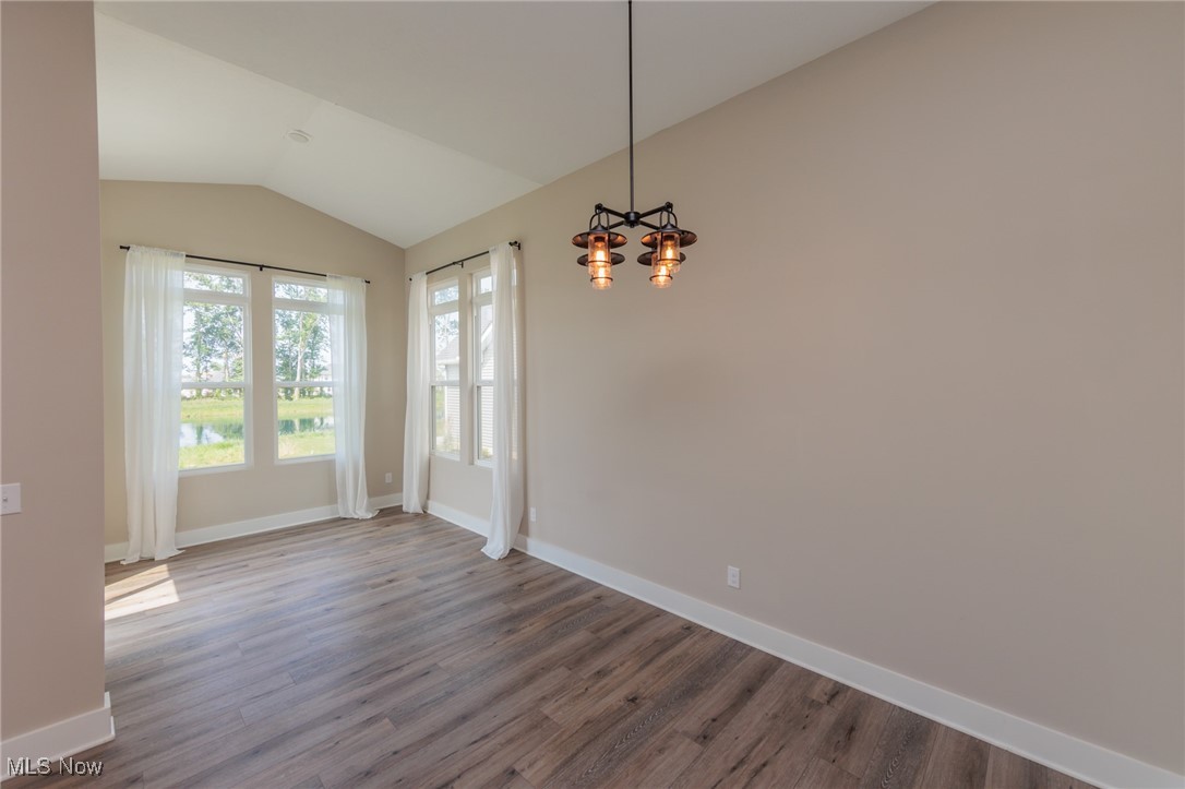 36458 Appian Way North Ridgeville, OH 44039 - Photo 7 of 37 Spare room with vaulted ceiling, dark hardwood / wood-style floors, and a chandelier