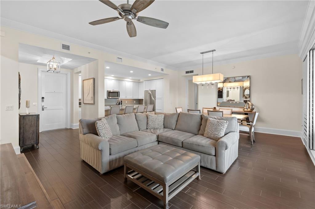 a living room with furniture kitchen view and a chandelier