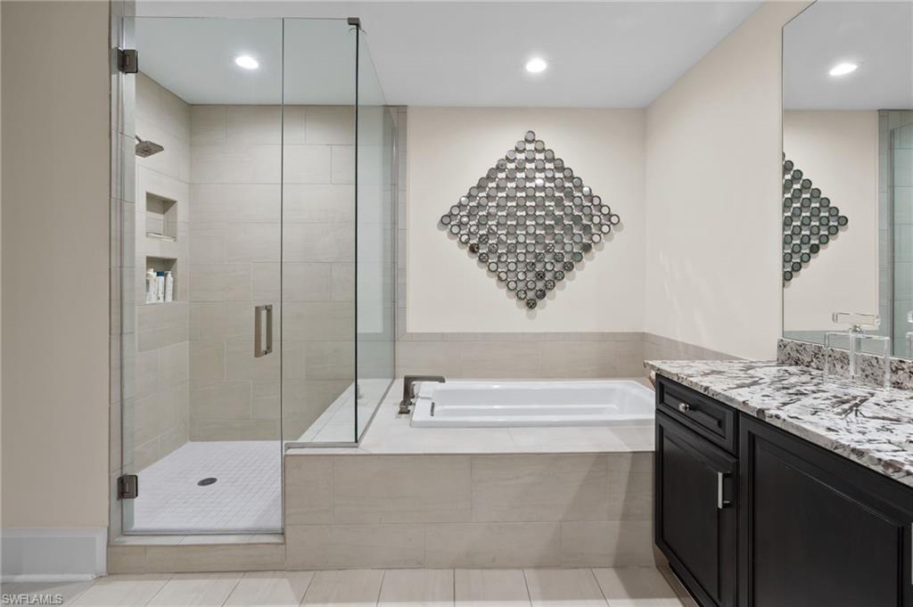 1030 3rd Avenue South, Unit 319 Naples, FL 34102 - Photo 12 of 42 a bathroom with a tub a sink and a shower