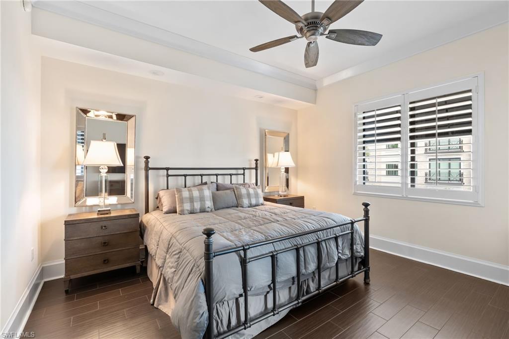1030 3rd Avenue South, Unit 319 Naples, FL 34102 - Photo 14 of 42 a bedroom with a bed and a chandelier