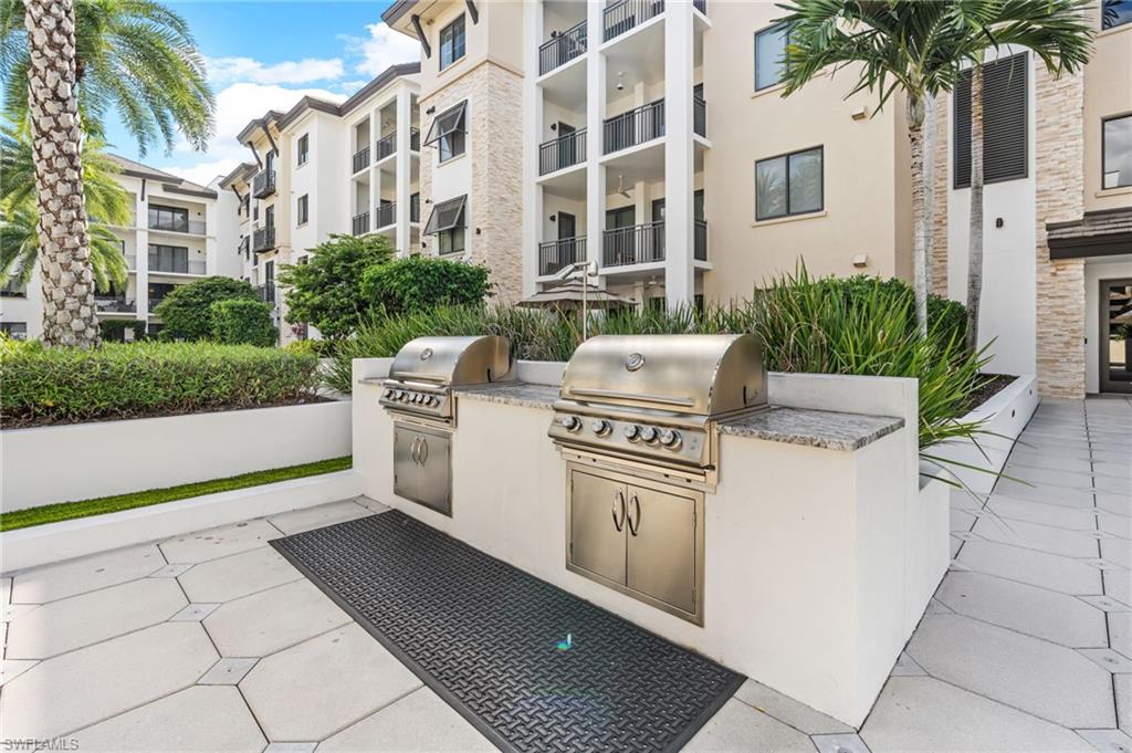 1030 3rd Avenue South, Unit 319 Naples, FL 34102 - Photo 27 of 42 a white building with glass top table and chairs