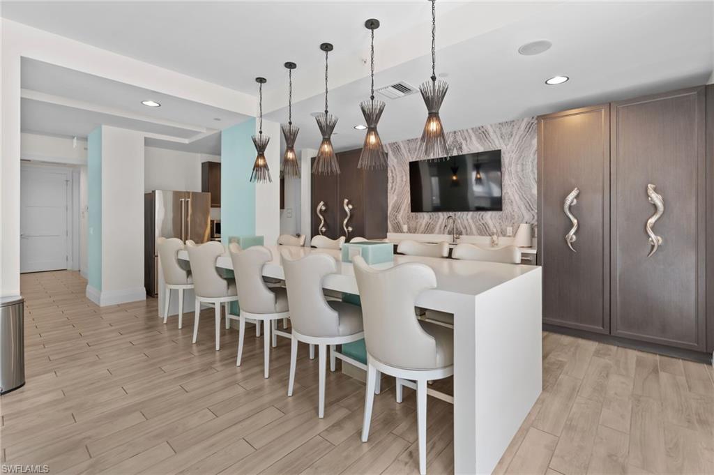 1030 3rd Avenue South, Unit 319 Naples, FL 34102 - Photo 35 of 42 a large kitchen with a table and chairs