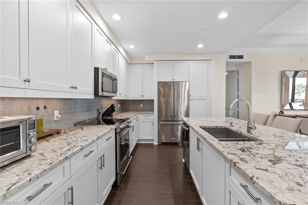 1030 3rd Avenue South, Unit 319 Naples, FL 34102 - Photo 9 of 42 a kitchen with a sink stove and refrigerator