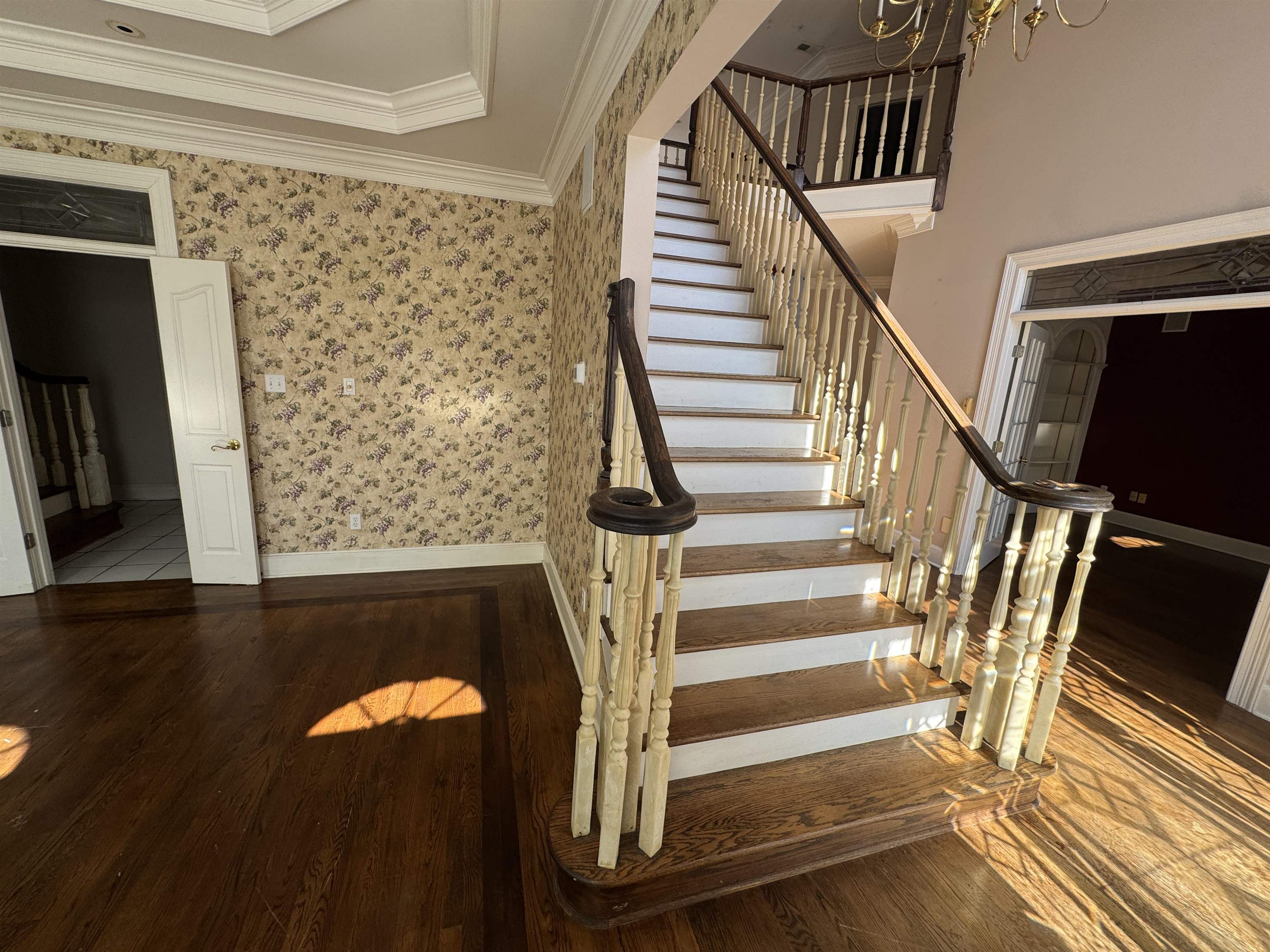 9500 Plantation Lake Road Collierville, TN 38017 - Photo 27 of 40 Stairway with crown molding, wallpapered walls, and wood finished floors