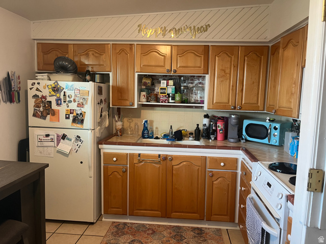 456 500 South Bountiful, UT 84010 - Photo 14 of 19 Kitchen with tile countertops, white appliances, decorative backsplash, and wood finish cabinetry