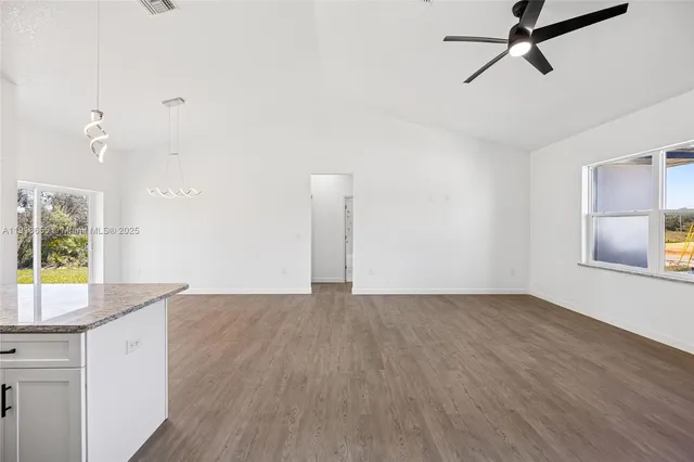 a view of a kitchen with wooden floor and a window