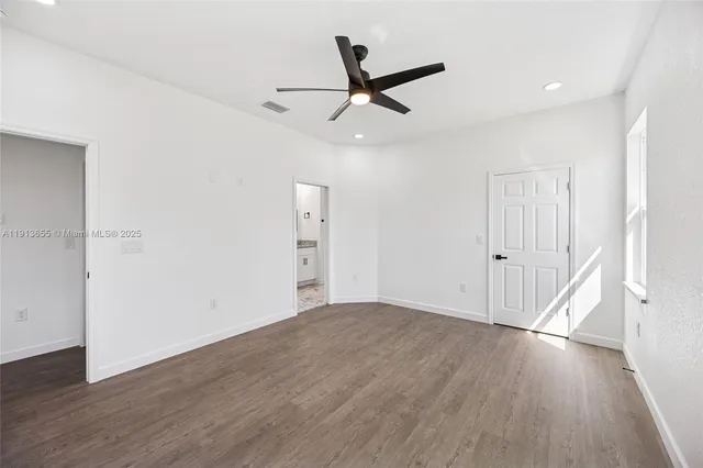 a view of empty room with wooden floor