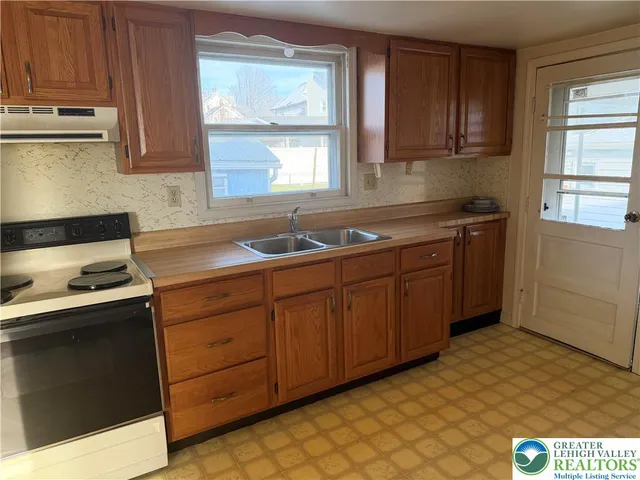 a kitchen with stainless steel appliances granite countertop a sink stove and cabinets