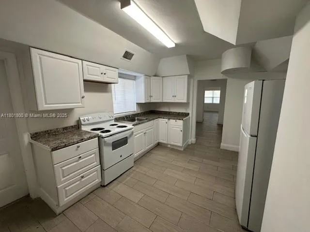 a kitchen with stainless steel appliances granite countertop a stove a refrigerator and a cabinets